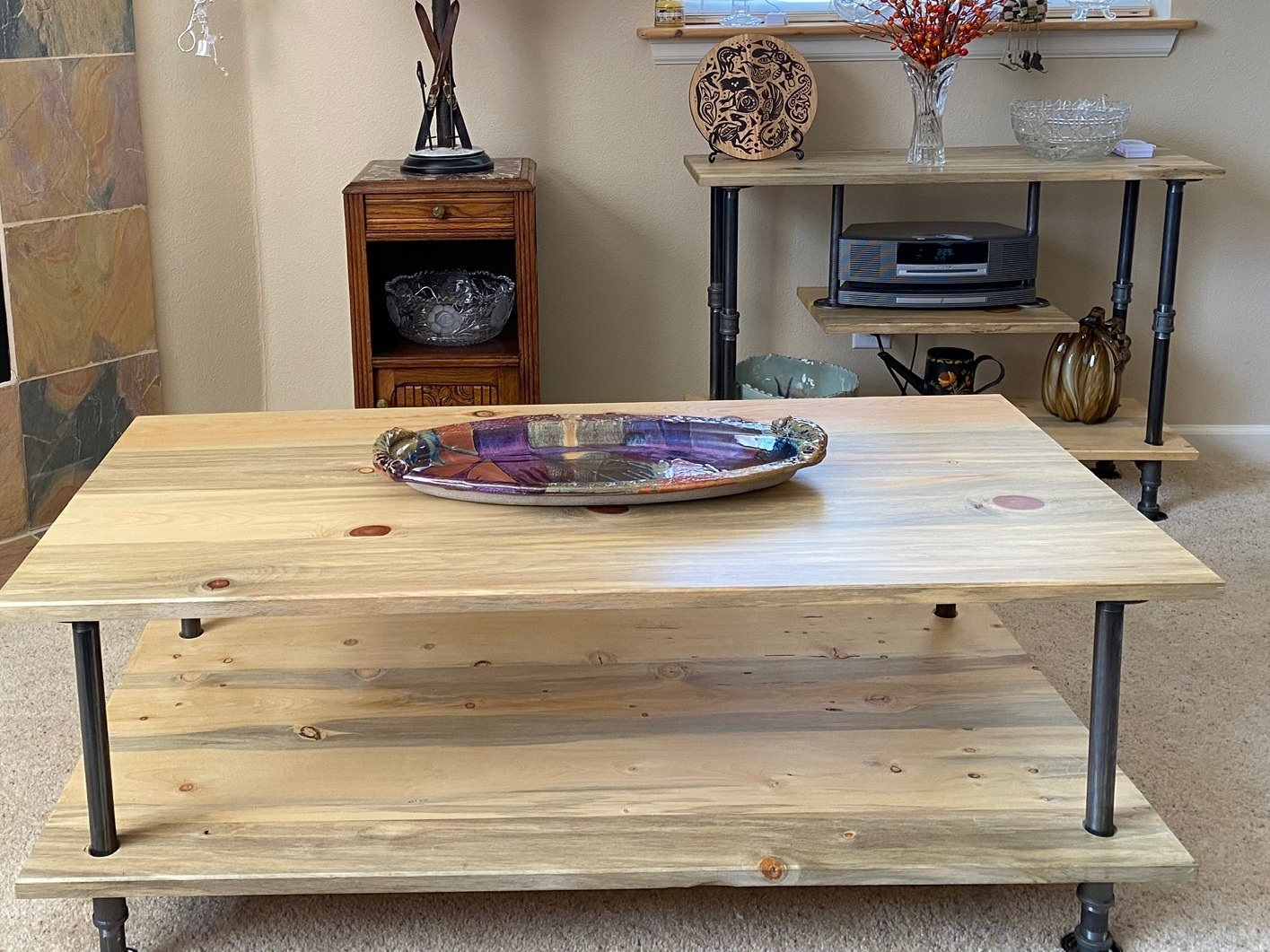 Custom-built two-tier coffee table in knotty pine with black pipe legs, with a matching console table behind it